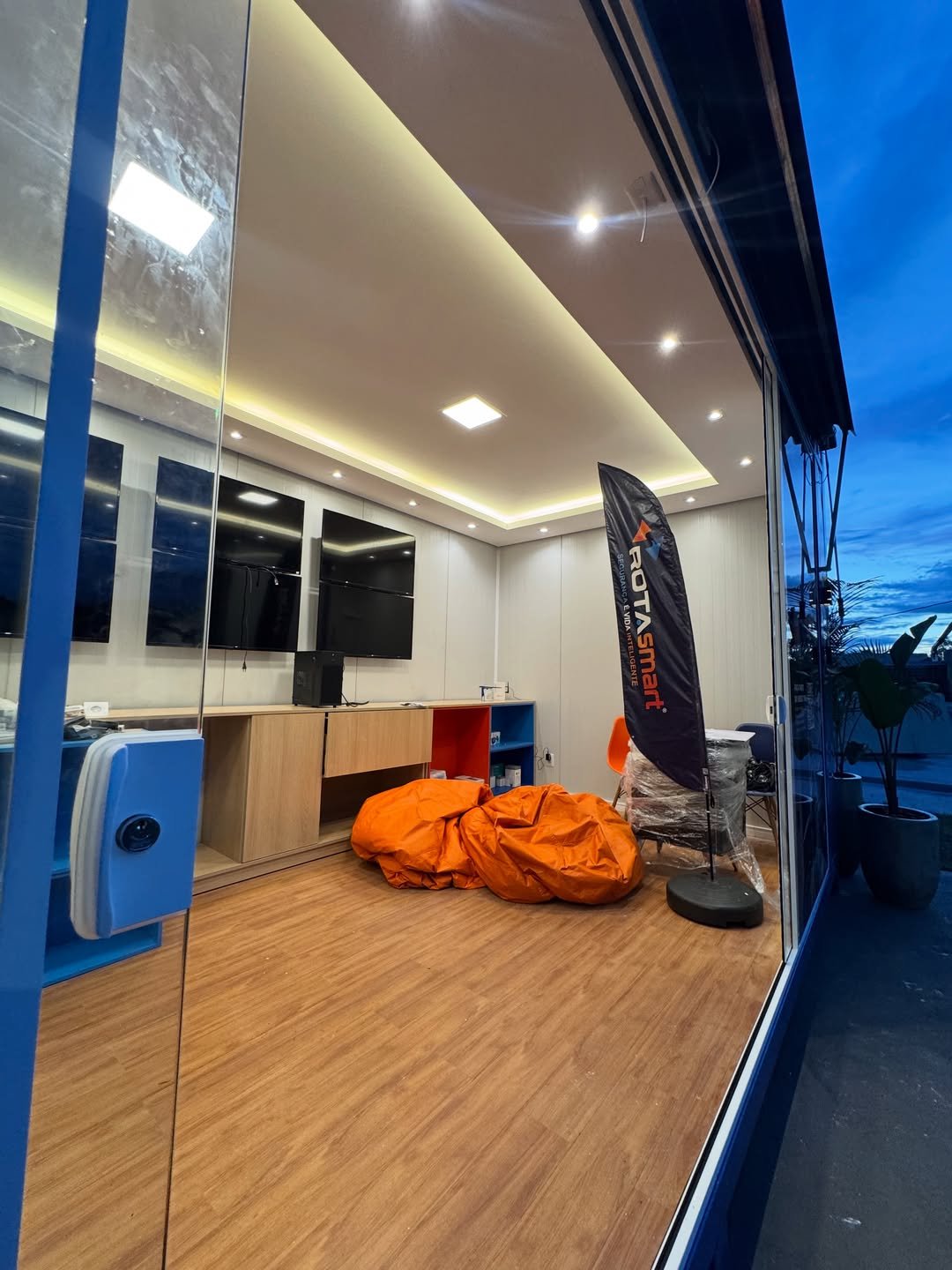 Vista pela entrada: iluminação, mobiliário e identificação da Rota Smart no escritório modular.